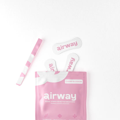 Pink 'airway' nasal strip packaging with three strips on a white background